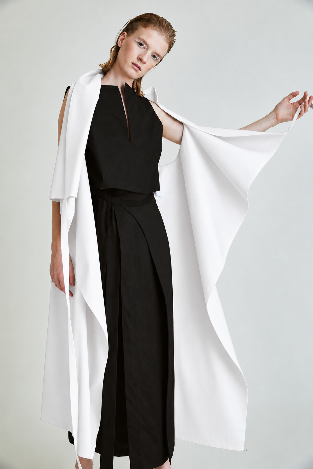 AI-assisted colour visualisation: TRANSFORMER VEST FORM / 08 in white, worn open over a black top and skirt.